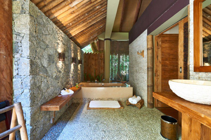 rustic-luxury-bathroom-with-exposed-stone-wall-718x479