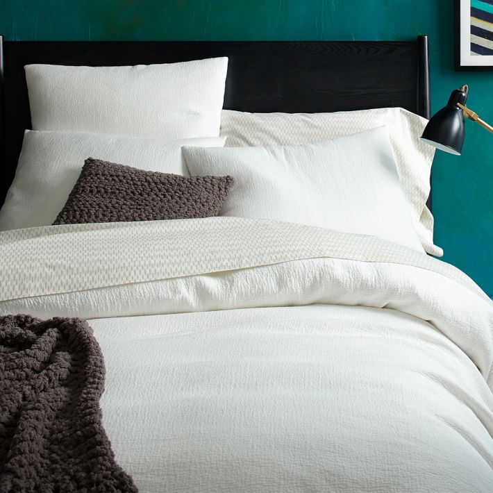 White-bedding-pops-against-a-teal-wall