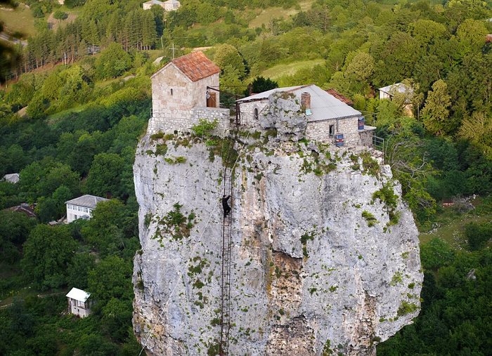 EMBARGOED UNTIL 0001 ON FRIDAY 6TH SEPTEMBER Mandatory Credit: Photo by REX/Amos Chapple (2596993b) Maxime climbs the ladder to the church and other buildings on top of the Katskhi Pillar Last of the Stylites Maxime Qavtaradze, who lives on top of the Katskhi Pillar, Georgia - 22 Jun 2013 *Full story: http://www.rexfeatures.com/nanolink/mik1 In an isolated region of the Caucasus a Georgian monk is spending his days in prayer and silence atop a 40-metre pillar of limestone. The Katskhi Pillar was used by stylites (Christian ascetics who lived atop pillars and eschewed worldly temptation) until the 15th century when the practice was stopped following the Ottoman invasion of Georgia. For centuries the 40 metres (130ft) high pillar lay abandoned and locals could only look up at the mysterious ruins at its summit. However, after first being ascended in 1944, the pillar has been home to Maxime Qavtaradze, last of the stylites, since 1993. Since then Maxime, who has previously spent time in prison, and the Christian community in the area have constructed a ladder to the top, rebuilt the church, and built a cottage where Maxime spends his days praying, reading, and "preparing to meet god".